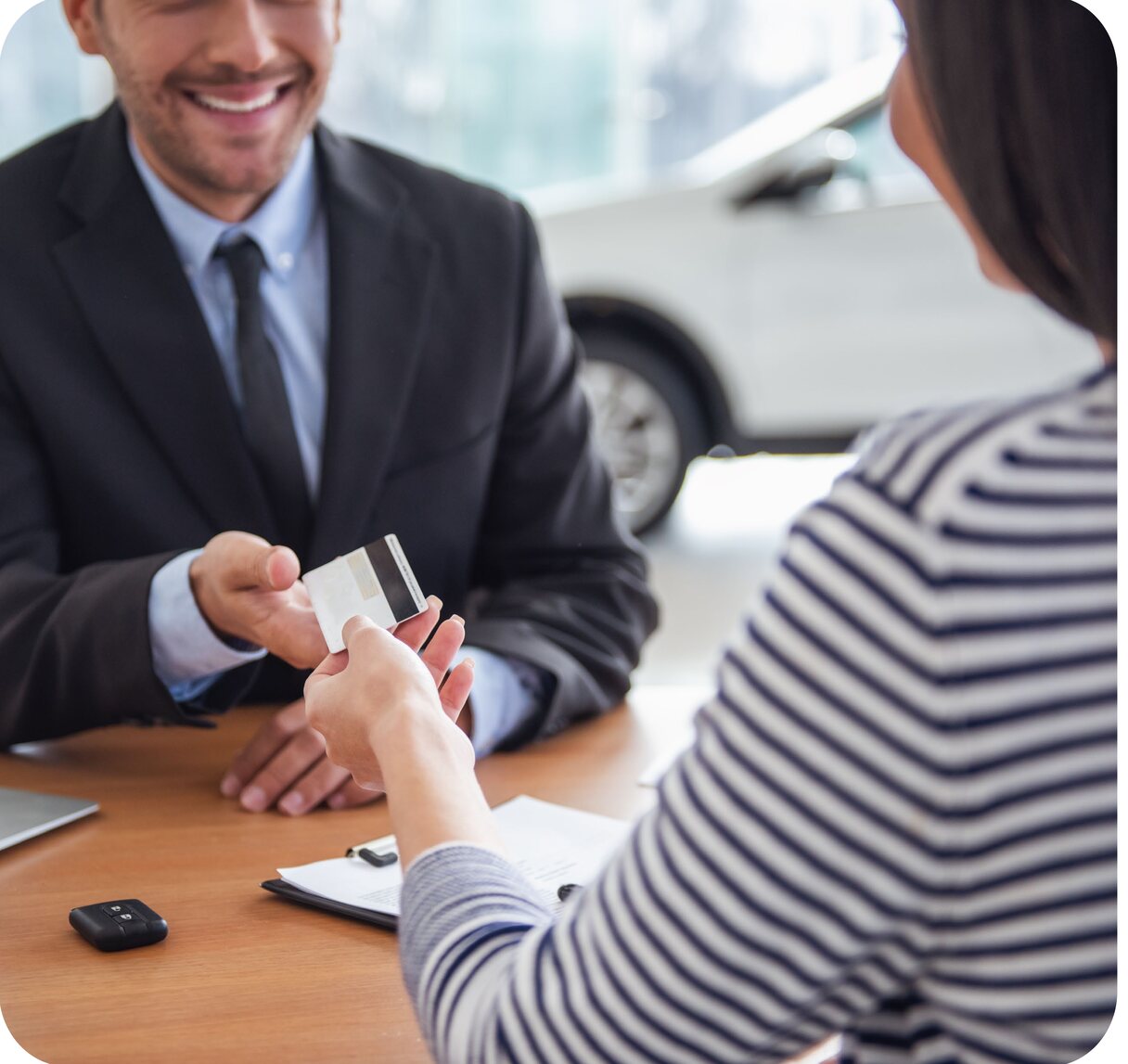 Dealership sales associate accepting a card payment from a customer